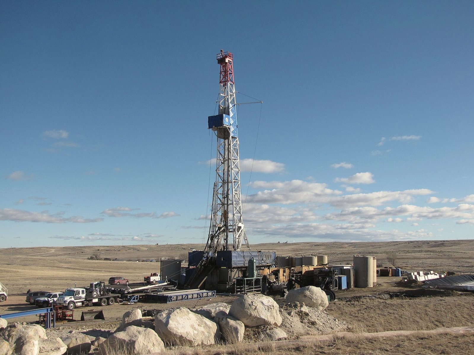 A drilling rig set up on a basin floor below the mountains
