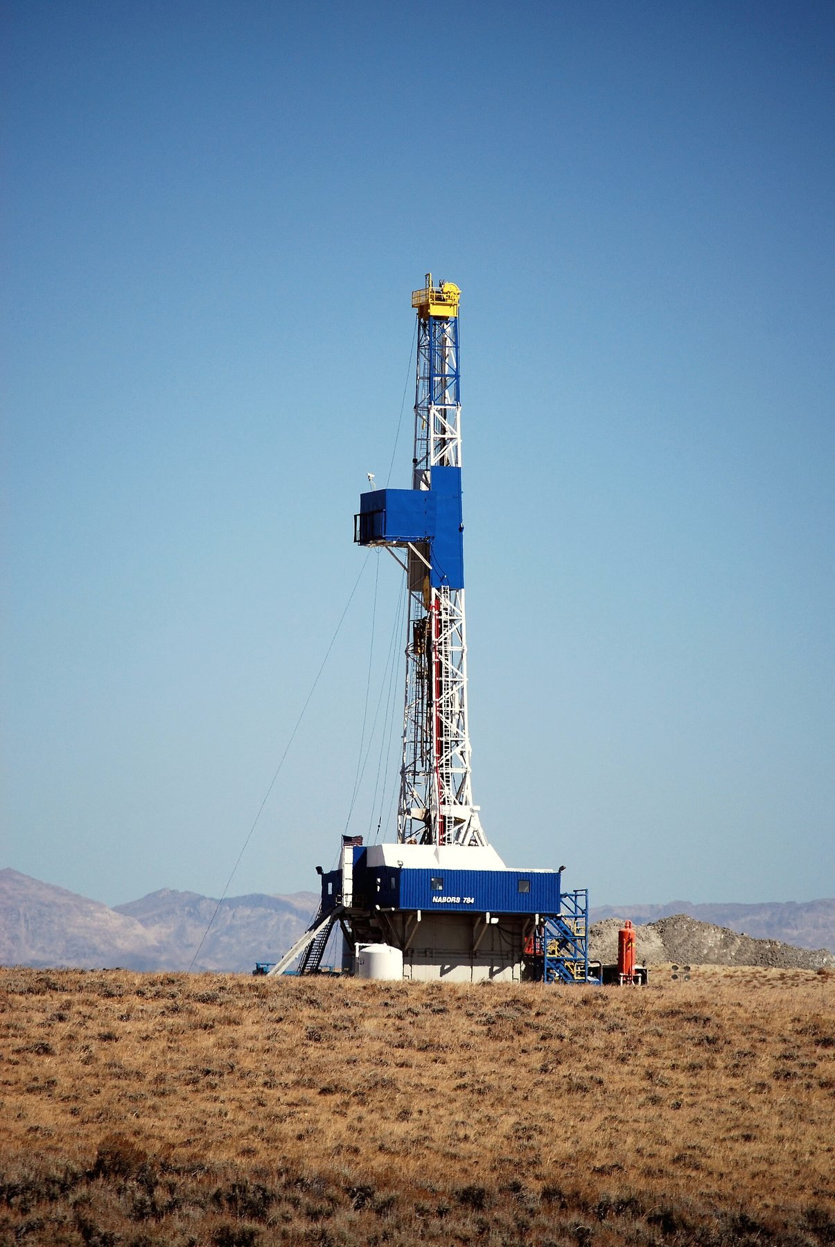 A drilling rig rigged up in open sagebrush