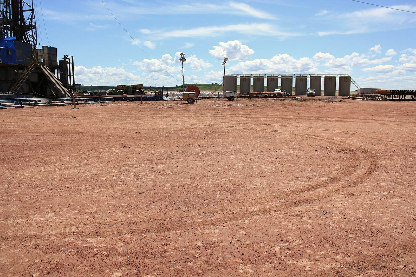 Tire tracks running across bare ground to a well pad